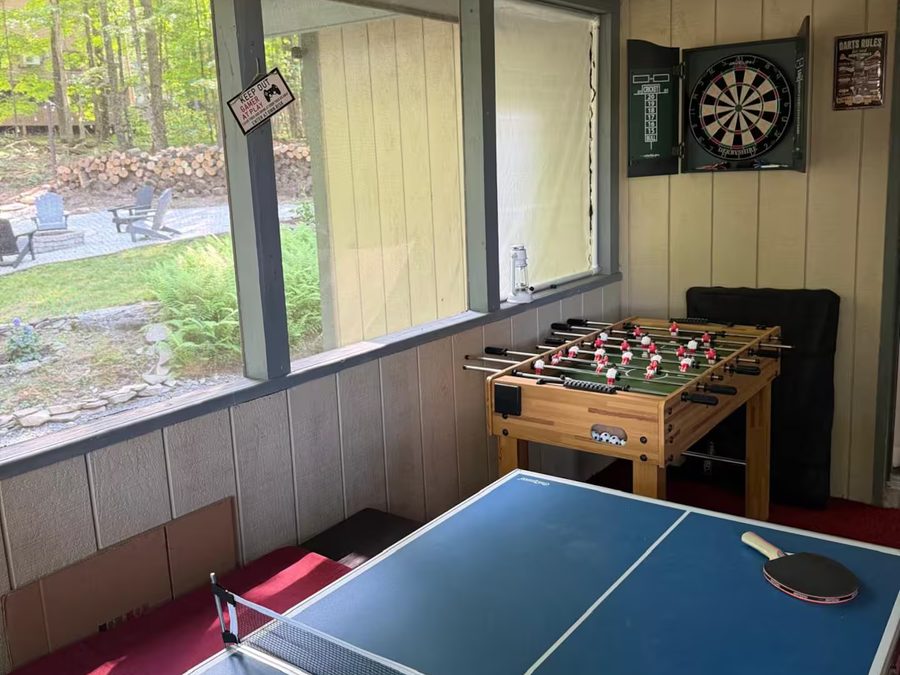 Game room with a ping pong table, foosball table, and dartboard